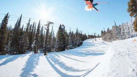 A skier jumps high up into the air going down a snowy run at the Eldora Mountain Ski Resort in Boulder County.