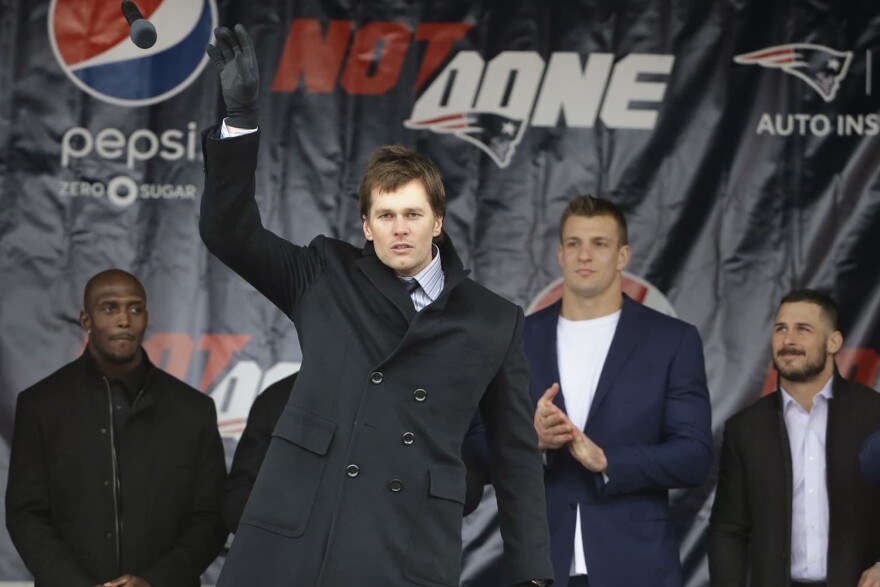 New England Patriots quarterback Tom Brady, center left, tosses a microphone after addressing a crowd during an NFL football Super Bowl send-off rally, Monday, Jan. 29, 2018, in Foxborough, Mass., as free safety Devin McCourty, left, tight end Rob Gronkowski, center right, and wide receiver Danny Amendola, right, look on. The Patriots are to play the Philadelphia Eagles in Super Bowl 52, Sunday, Feb. 4, in Minneapolis. (AP Photo/Steven Senne)