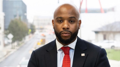 A man looks straight into a camera for a headshot pose.