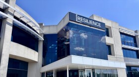 A large building concrete with lots of windows and a word displayed at the very top: Resilience