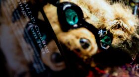 This photo illustration shows the DALL-E website on a cellphone, in front of an AI image created using DALL-E technology displayed on a computer screen.