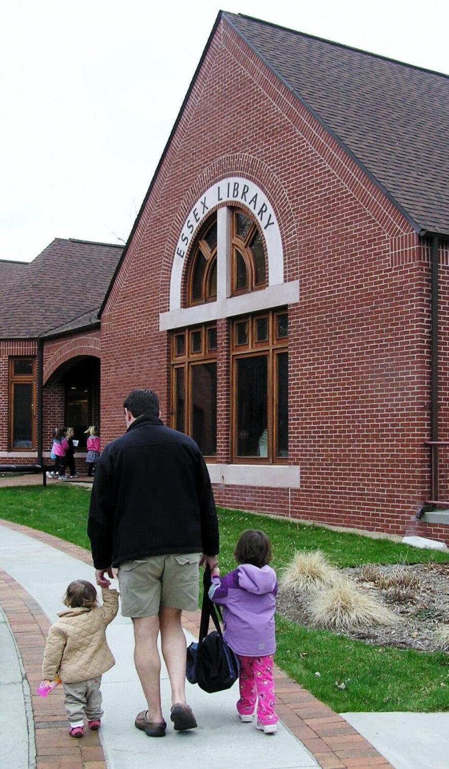 A man walks with two children into the Essex Public Library. (Courtesy Essex Library)