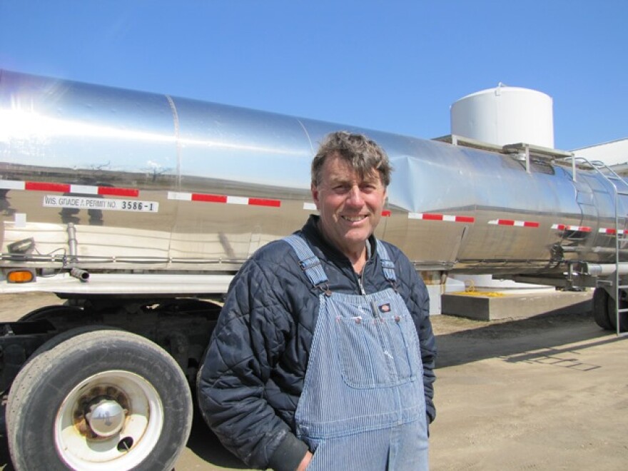 Dairy farmer John Rosenow stands in front of a semi truck. His 550 dairy cows fill one semi every day to sell across the street to the cheese factory.