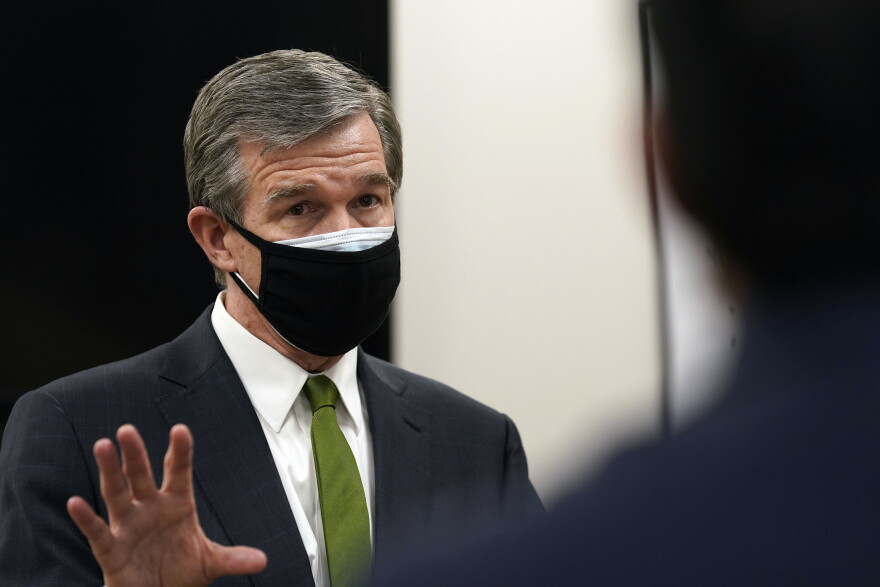 North Carolina Gov. Roy Cooper speaks during a tour of Piedmont Health Senior Care, a federally qualified health center where PACE patients (Program of All-Inclusive Care for the Elderly) and underserved populations receive the coronavirus vaccine Thursday, Jan. 28, 2021 in Pittsboro, N.C. 