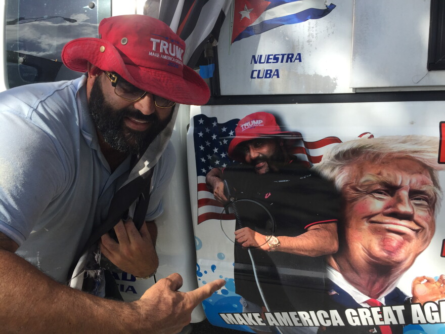 Conservative Cuban-American voter Alberto Hernandez shows off the picture of President Trump on his painting company's pickup truck in Kendall on Tuesday.