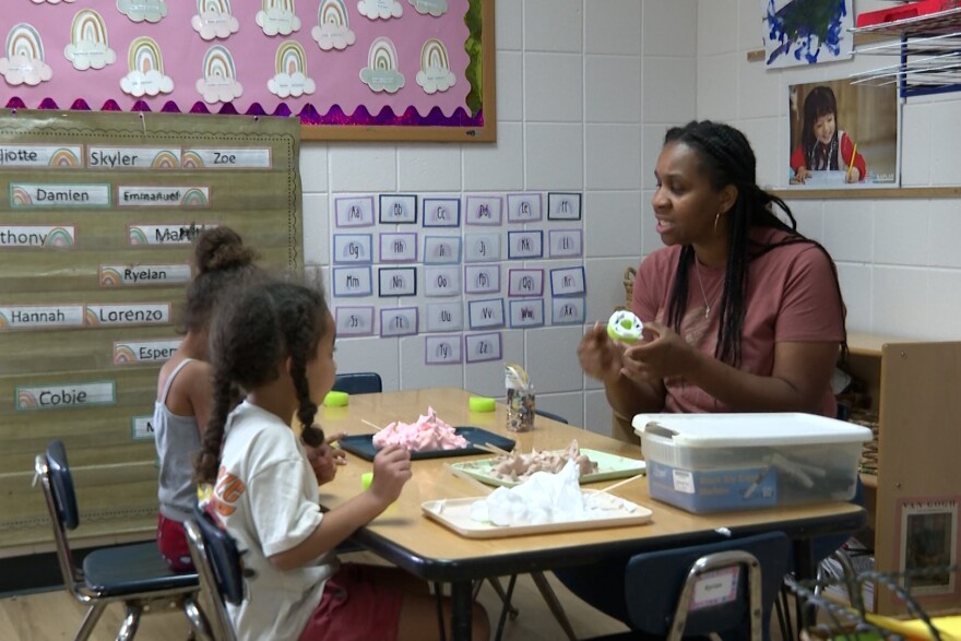 Shannon Moore does an activity with a couple of her students in the classroom.