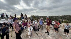 Bible teacher/tour guide Jeff Weima (in grey ball cap) speaks to tour members at Mars Hill, where apostle Paul preached to the Athenians about the unknown God, described in Acts 17.