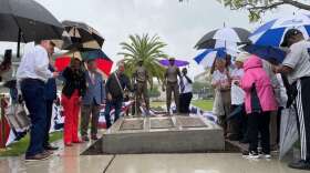 Elected leaders and community residents huddled in the rain to celebrate the new monument. Photo by Amy Green