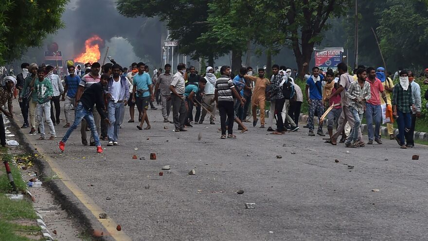 Some of the tens of thousands of Gurmeet Ram Rahim Singh's followers who gathered this week in Panchkula in Haryana state are seen throwing stones at security forces during clashes after the controversial guru was convicted of rape.