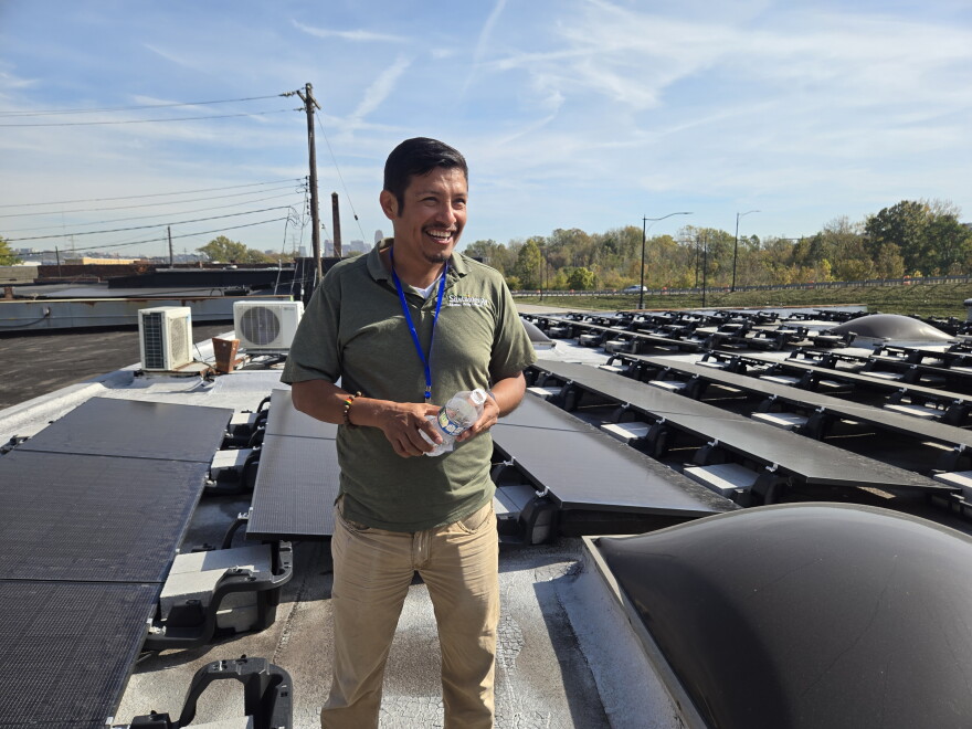 Sustainergy CEO Flequer Vera shows off the employee-owned company's solar array on its roof. The 20-employee company installs solar panels and energy efficiency material for homes and businesses. Vera is also vice president of Co-op Cincy, which advocates for employee ownership.