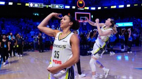 Dallas Wings guard Azzi Fudd (35) and Paige Bueckers, rear, toss keepsakes to fans after the team's win in a WNBA basketball game against the Connecticut Sun in Arlington, Texas, Sunday, Aug. 2, 2026.