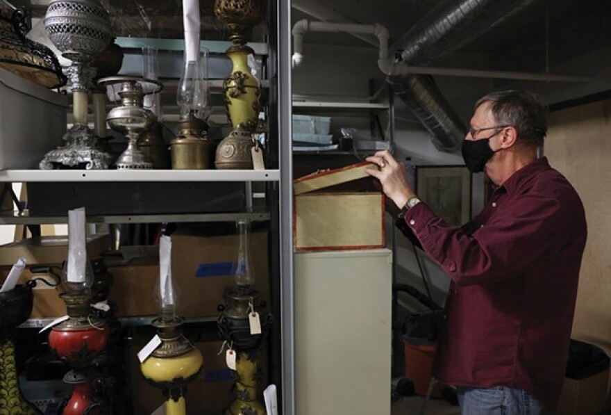 Rochester Historical Society archivist Bill Keeler examines a handmade tackle box that once belonged to Seth Green. Green was pioneer in fish farming and established the first fish hatchery in the United States.