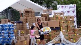 A woman with a child carries a box of food assistance she received from the Second Harvest Food Bank of Central Florida. (Paul Hennessy/NurPhoto via Getty Images)