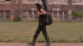 Rodriguez carries his guitar through Detroit, Mich., his hometown.
