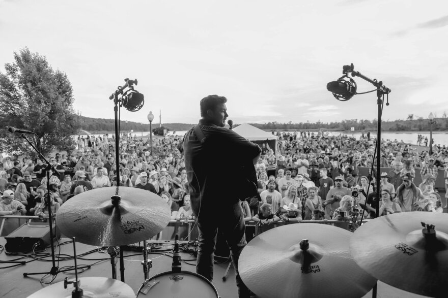B&W Photo of Ian Flannigan on stage from behind