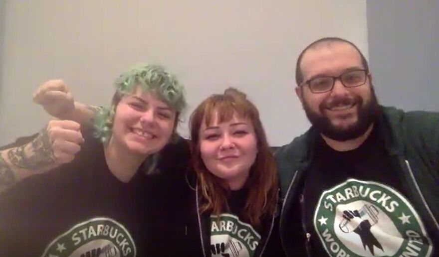 three people pose for a photo, all wearing Starbucks union shirts