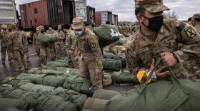 Army soldiers retrieve their duffel bags after they returned home from a nine-month deployment to Afghanistan on Dec. 10, 2020 at Fort Drum, New York. (John Moore/Getty Images)