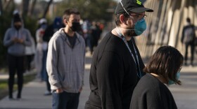People wait in line for a COVID-19 test at a testing site in Los Angeles on Tuesday. California is starting to feel the full wrath of the omicron variant. Hospitalizations have jumped nearly 50% since Christmas and models show that in a month the state could have 22,000 people in hospitals, which was the peak during last winter's epic surge.