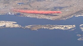 A tanker drops retardant to stop the spread of the Kasigluk Fire (#139) in the village of Kasigluk in Southwest Alaska