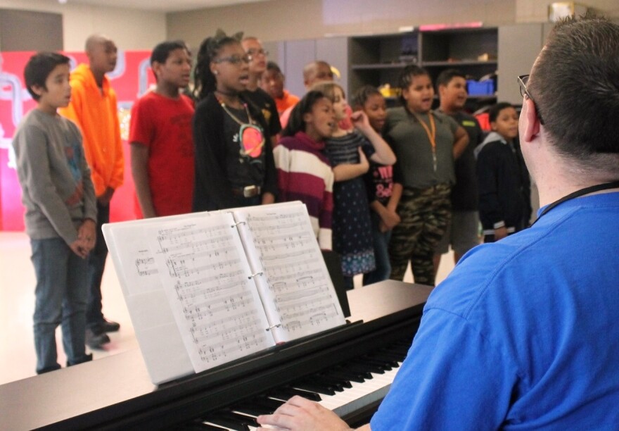 Music teacher Anthony Volkman rehearses a song about snow with a dozen Ackerman School children.