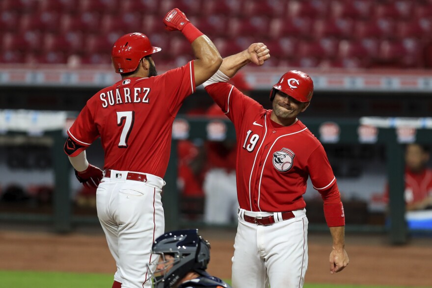 Cincinnati Reds' Eugenio Suarez (7) celebrates hitting a two-run home run with Joey Votto (19) during the eighth inning of an exhibition baseball game against the Detroit Tigers at Great American Ball Park.
