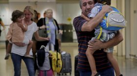Juan Rojas, right, of Queens, hugs his 4-year-old grandson Elias Rojas, as his daughter-in-law Cori Rojas, left, carries her daughter Lilly, 3, through the terminal at JFK airport after Cori arrived on a flight from San Juan, Puerto Rico, Tuesday, Sept. 26, 2017, in New York. (Julie Jacobson/AP)