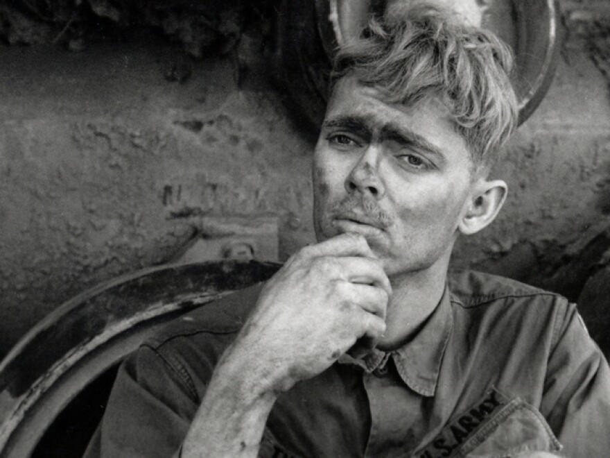 An American soldier reads a letter from home, while taking a break from repairing a tank tread in Lang Vei, Vietnam, in March 1971.