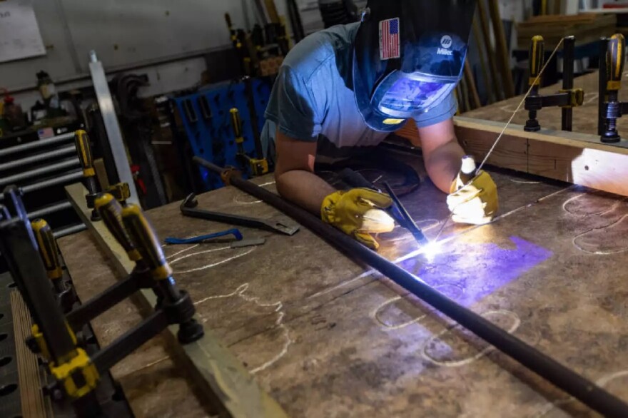 Sincere Metal Works welder TJ Sadowski begins welding the bronze panels of Nancy Schon’s “Noble Journey Sculpture” to create one piece.