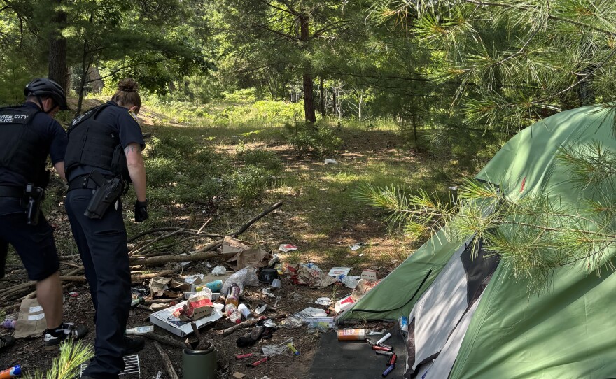 Traverse City Police Officer Krista Fryczynski and Officer Justin Nowland check out a campsite on private property behind Lear Corporation.
