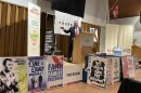 A man stands at a podium surrounded by signs that say phrases including "freedom" and "team America"