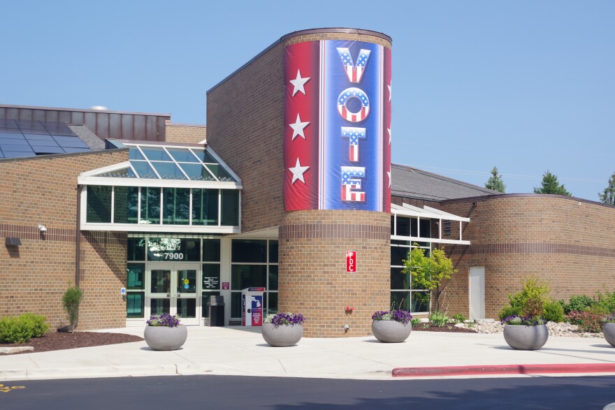 big banner on the Portage City Hall brown brick building that says "vote" in vertical letters with a red-white-and-blue theme