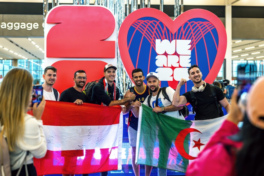 Austria and Algeria supporters pose for a photo at Kansas City International Airport as they arrive for the next match in Kansas City on Saturday. The airport has added translators inside the terminal for both Spanish and for Arabic to help keep lines moving.