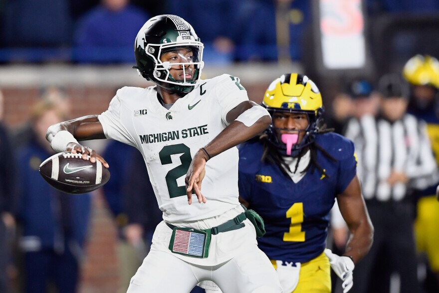 FILE - Michigan State quarterback Aidan Chiles, left, prepares to throw as Michigan linebacker Jaishawn Barham chases him in the second half of an NCAA college football game, Saturday, Oct. 26, 2024, in Ann Arbor, Mich. (AP Photo/Jose Juarez, File)