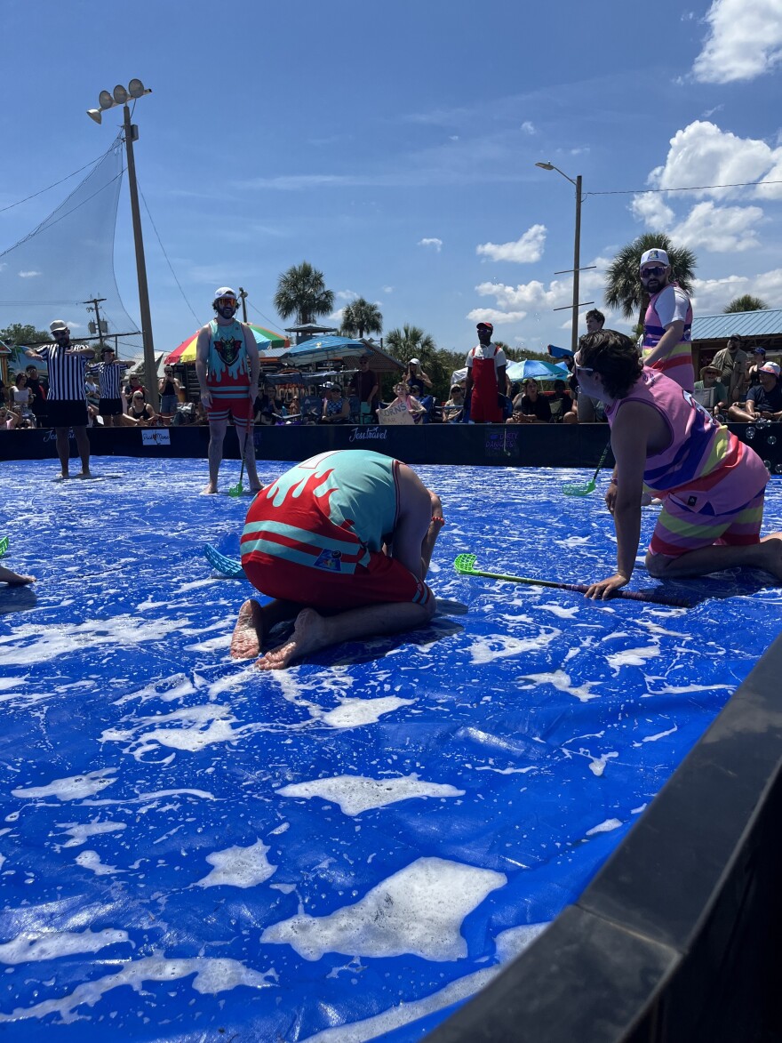 Man upset on his hands and knees during soap hockey game