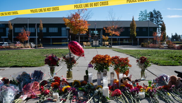 Flowers and candles are seen at a makeshift memorial outside Silver Rail Elementary in Bend, Ore., Friday, Oct. 16, 2026, a day after a deadly shooting.