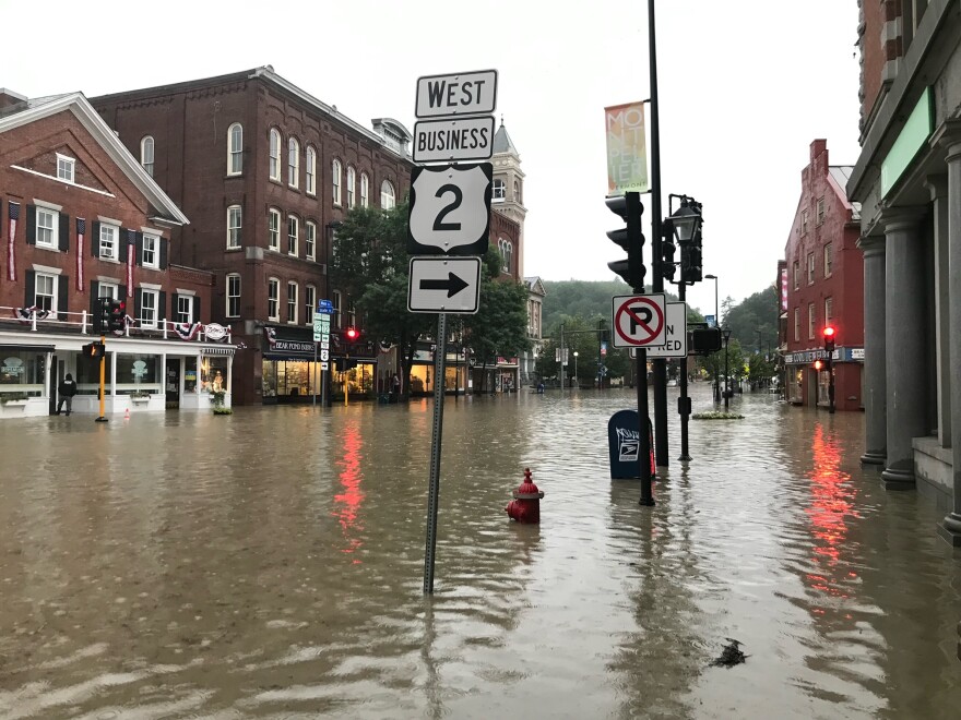 A city street in Montpelier, with old brick buildings on each side, with several feet of water covering the road