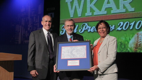 MSU Provost Kim Wilcox (left) and WKAR General Manager DeAnne Hamilton (right) presented David Hollister with a framed replica of a blueprint of Oldsmobile Park, home of the Lansing Lugnuts and known today as Cooley Law School Stadium, on Aug. 31, 2010.