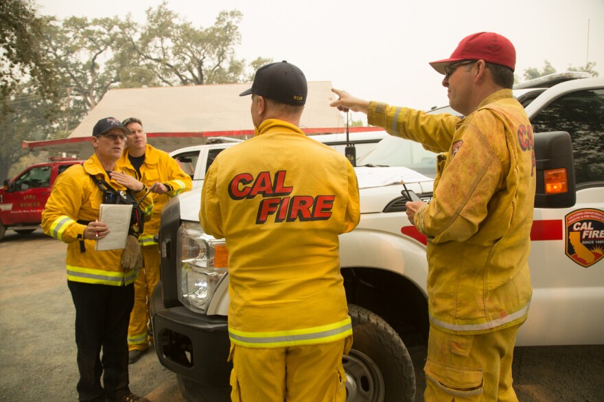 CalFire firemen compare notes near the Tubbs fire just north of Calistoga. (Photo by Clark Mishler)