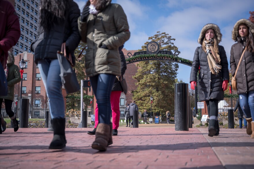 Students cross Grand Boulevard on St. Louis University's campus Tuesday.