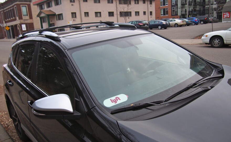 A car with a sticker on the windshield that indicates it participates in the rideshare community.