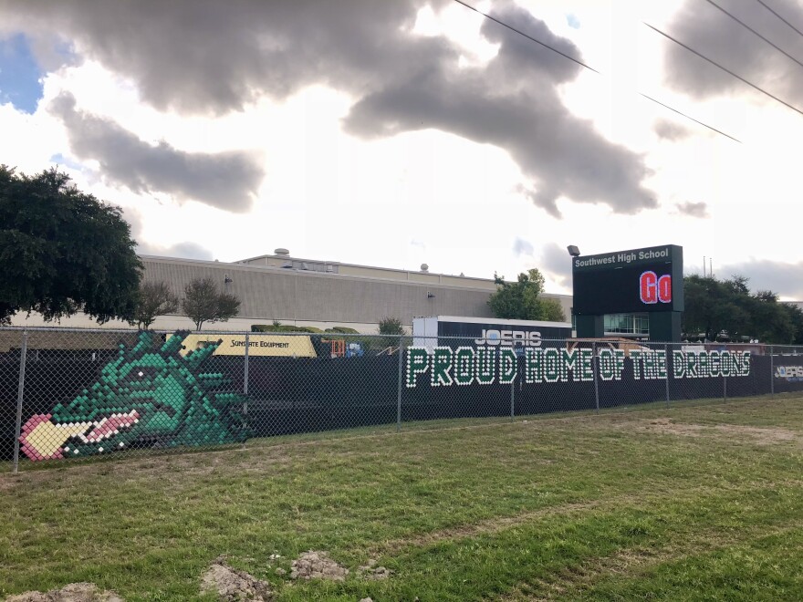 A fence around Southwest High School is decorated with a fire breathing dragon and the phrase "Proud home of the dragons" in August 2018.