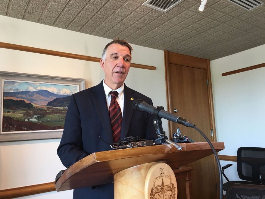 Gov. Phil Scott, addressing reporters from a podium at a press conference