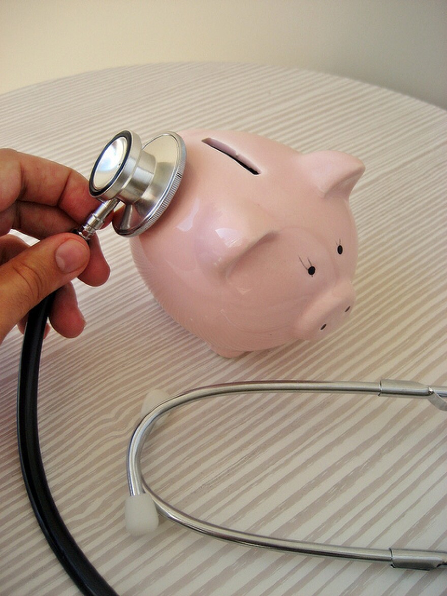 stethescope listening to piggy bank