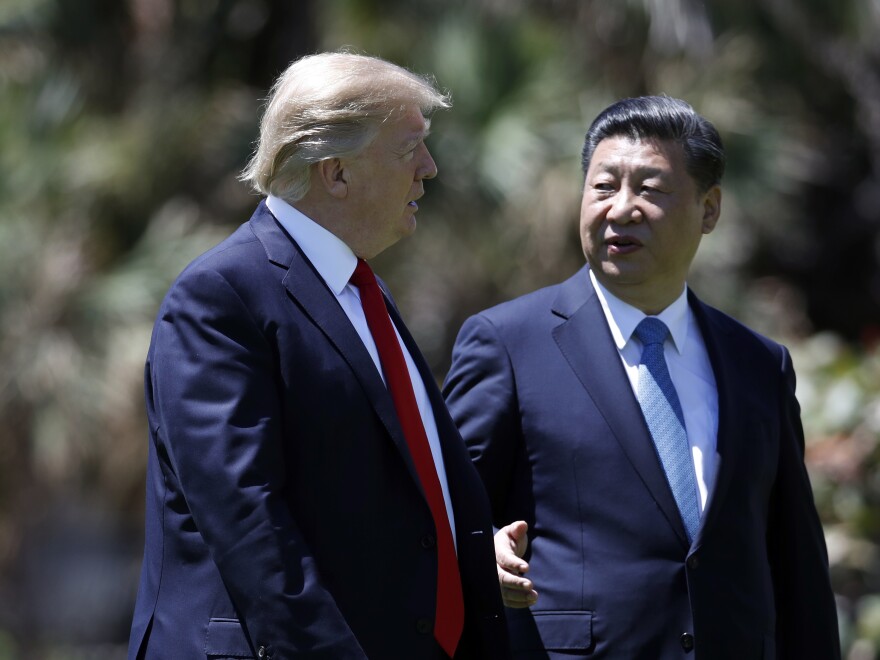 President Donald Trump and Chinese President Xi Jinping walk together after their meetings at Mar-a-Lago, on Friday, April 7, 2017, in Palm Beach, Fla.