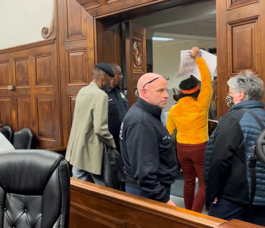 Protesters of the White Pond Reserve development are escorted from the Akron City Council chambers Monday night.