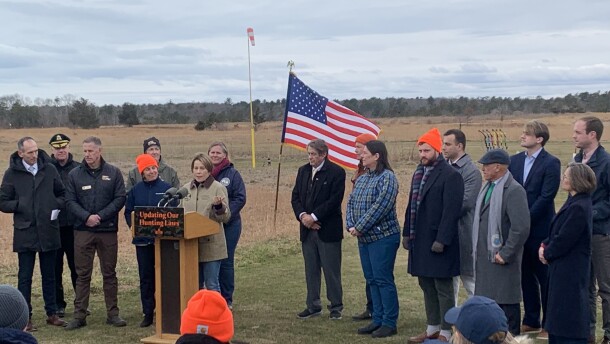 Governor Maura Healey (at the podium) announced that alpha-gal syndrome will become a reportable condition in Massachusetts at the Frances A. Crane Wildlife Management Area in North Falmouth. Massachusetts Public Health Commissioner Dr. Robbie Goldstein (leftmost person standing) spoke about the importance of collecting data on the emerging condition.