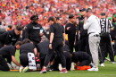 Oregon head coach Dan Lanning, right, stands by as Oregon quarterback Dante Moore is attended to on the field.
