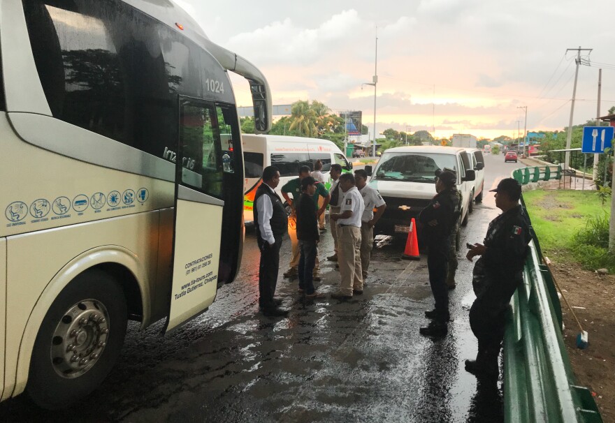 Mexican immigration agents take a man off a bus at a highway checkpoint. Both federal police and the Mexican army also participate in these highway checkpoints.