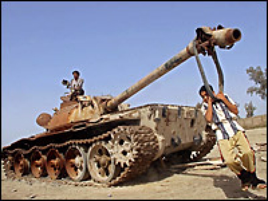A boy uses the cannon of a destroyed Iraqi army tank as a swing on March 18, 2006, near Basra. Defeating the Iraqi military turned out to be easier than bringing peace and stability back to the country after the invasion.