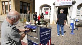 FILE - A voter submits a ballot in an official drop box during early voting in Athens, Ga., on Oct. 19, 2020. The widespread use of absentee ballot drop boxes during the 2020 election was largely trouble-free, contrary to claims made by former President Donald Trump and his Republican allies. An Associated Press survey of state election officials across the U.S. revealed no problems that could have affected the results, including from fraud, vandalism or theft. (AP Photo/John Bazemore, File)